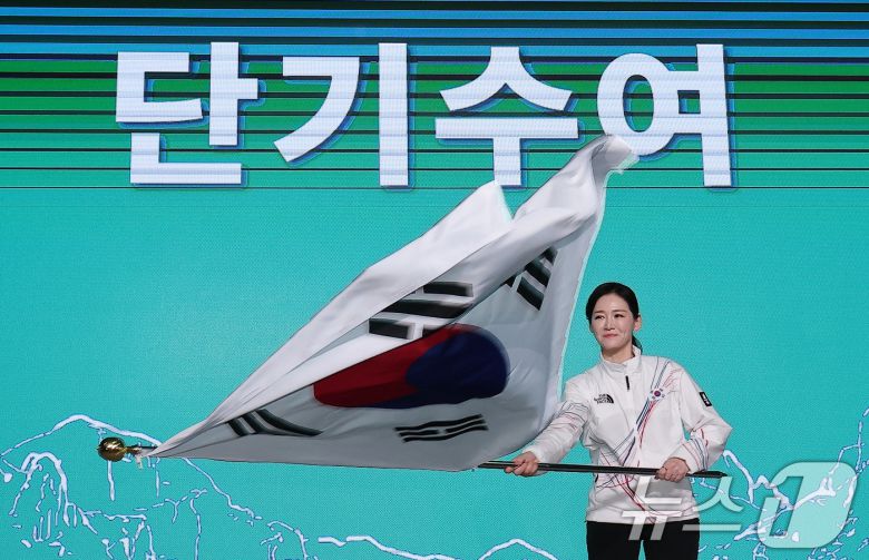 이수경 선수단장이 22일 서울 송파구 올림픽파크텔에서 열린 2026 밀라노코르티나 동계올림픽대회 결단식에서 유승민 대한체육회장에게 수여받은 단기를 흔들고 있다. 2026.1.22/뉴스1 ⓒ News1 김성진 기자