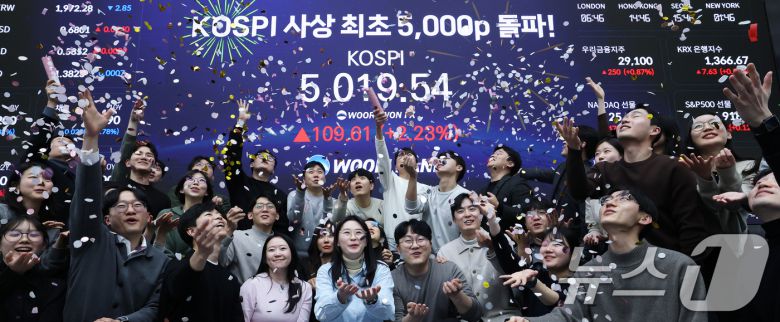 22일 서울 중구 우리은행 본점 딜링룸에서 직원들이 장중 최고가가 찍힌 전광판을 배경으로 코스피 5000 돌파를 축하하고 있다. 2026.1.22/뉴스1 ⓒ News1 오대일 기자