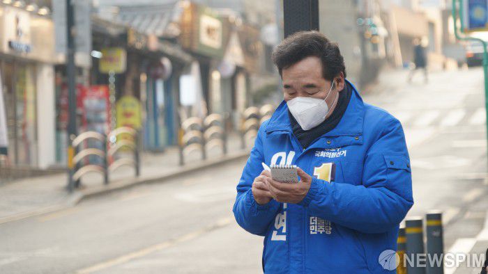 [서울=뉴스핌] 4·15 총선 더불어민주당 후보로 종로에 출마하는 이낙연 전 국무총리가 20일 오전 서울 종로구 재동에서 아침 인사를 하던 중 주민의 얘기를 메모장에 적고 있다 . [사진=이낙연 캠프] 2020.02.20 photo@newspim.com