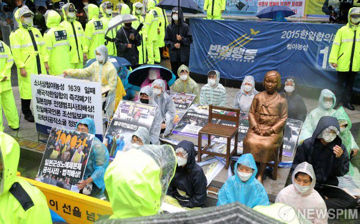 [서울=뉴스핌] 백인혁 기자 = 28년만에 소녀상 앞 자리에서 밀려나 근처에서 제1445차 정기 수요 시위가 열린 24일 오후 서울 종로구 옛 일본대사관 앞 소녀상에서 반아베반일청년학생공동행동 관계자 및 소속 학생들이 소녀상 철거를 요구하는 단체 관계자들로부터 소녀상을 지키기 위해 연좌시위를 벌이고 있다. 2020.06.24 dlsgur9757@newspim.com