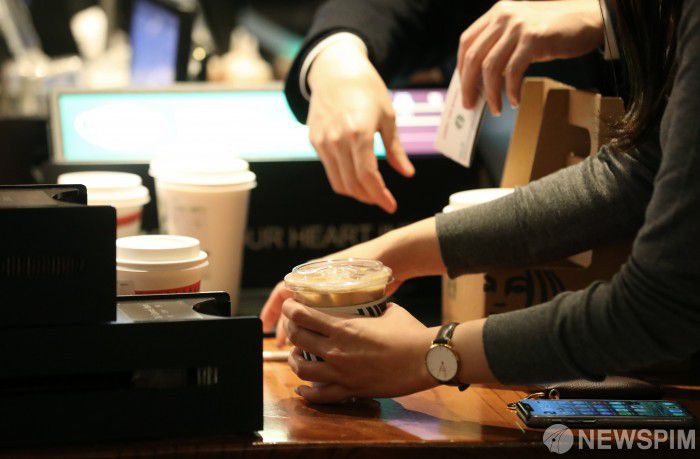 [서울=뉴스핌] 정일구 기자 = 신종 코로나바이러스 감염증(코로나19) 재확산으로 수도권 지역 사회적 거리두기가 2단계로 격상된 24일 오후 서울 시내 한 카페에서 고객들이 포장 주문을 하고 있다. 이날부터 사회적 거리두기 2단계로 격상됨에 따라 유흥시설은 운영할 수 없고, 카페는 영업시간과 관계없이 포장·배달만 허용되며 음식점은 저녁시간까지 정상영업을 하되 오후 9시 이후로는 포장·배달만 가능하다. 2020.11.24 mironj19@newspim.com