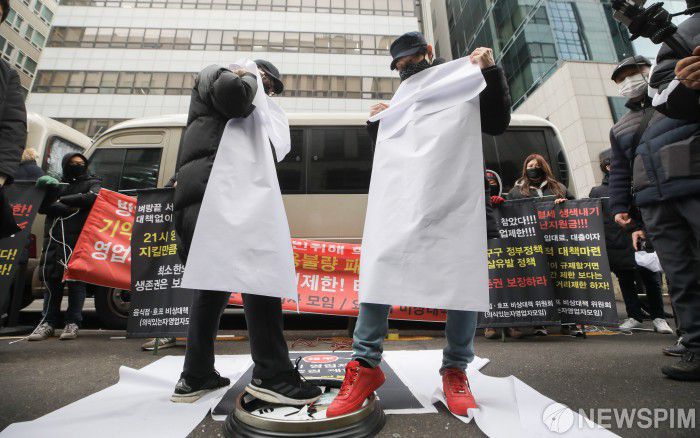 [서울=뉴스핌] 최상수 기자 = 음식점·호프 비상대책위원회(의식있는자영업자모임)이  15일 오후 서울 여의도 더불어민주당사 앞에서 기자회견을 열고 정부의 코로나19 방역 관련 21시 영업제한 정책 철회를 촉구하는 퍼포먼스를 하고 있다. 2021.01.15 kilroy023@newspim.com