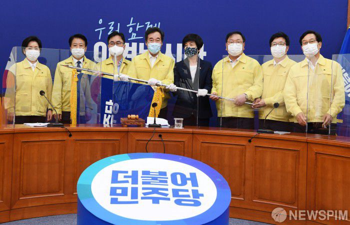 [서울=뉴스핌] 최상수 기자 = 이낙연 더불어민주당 신임 당대표가 지난해 8월 31일 오후 서울 여의도 국회에서 열린 더불어민주당 최고위원회의에 참석해 김영주 전국대의원대회 의장에게 당기를 받고 있다. 왼쪽부터 양향자 최고위원, 노웅래 최고위원, 김종민 최고위원, 이낙연 대표, 김영주 의장, 김태년 원내대표, 염태영 최고위원, 신동근 최고위원. 2021.03.30 kilroy023@newspim.com