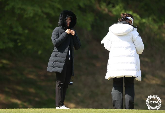 강풍에 롱패딩 입은 선수들이 1번홀 그린에 대기하고 있다. [사진= KLPGA]