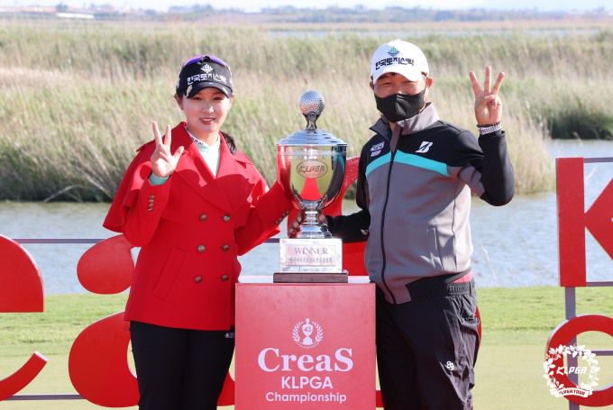 부친과 함께 트로피를 들어올린 박현경. [사진= KLPGA]