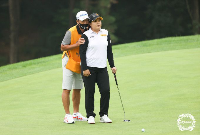 골프백을 멘 남편 남기협 코치가 박인비와 코스에 대해 상의하고 있다. [사진= KLPGA]