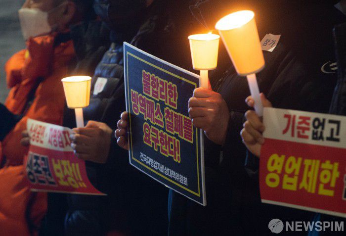 [서울=뉴스핌] 윤창빈 기자 = 10일 오후 서울 여의도 국회의사당 인근에서 열린 자영업자 연대궐기에 참가한 자영업자들이 피켓과 촛불을 들고 있다. 2022.01.10 pangbin@newspim.com