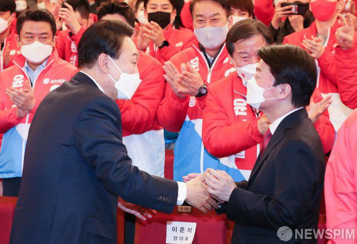 [서울=뉴스핌] 이형석 기자 = 윤석열 대통령 당선인과 안철수 국민의당 대표가 10일 새벽 서울 여의도 국회도서관에 마련된 '국민의힘 제 20대 대통령선거 개표상황실'에서 악수를 하고 있다. 2022.03.10 leehs@newspim.com