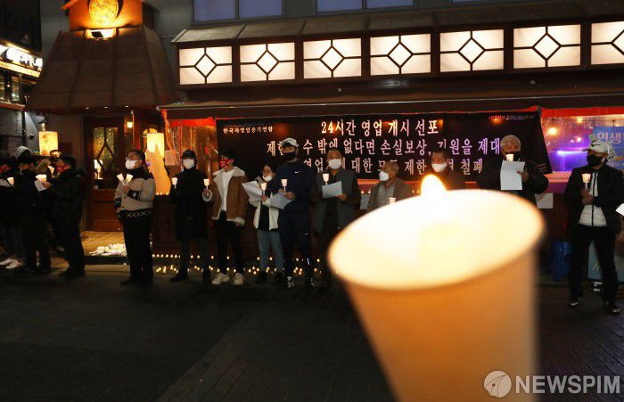 [서울=뉴스핌] 김민지 기자 = 한국자영업중기연합 회원들이 25일 밤 서울 종로구 먹자골목에서 24시간 영업개시 선포식을 하고 있다. 이날 일부 자영업자들은 정부의 밤 10시 영업 제한을 거부하고 24시간 영업을 선포했다. 2022.02.25 kimkim@newspim.com