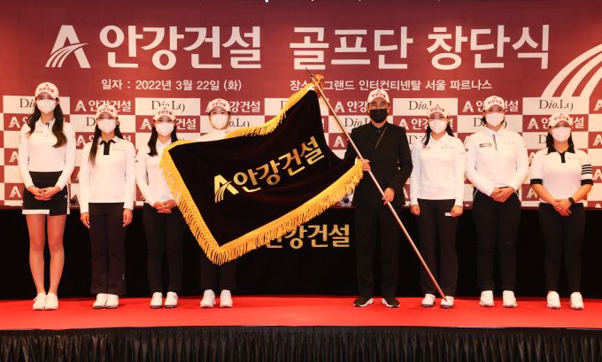 안재홍 회장과 선수들이 회사기를 들고 기념 촬영을 하고 있다. [사진= 안강건설]