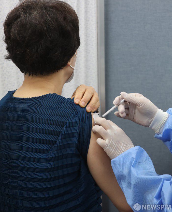[서울=뉴스핌] 김민지 기자 = 50대와 18세 이상 성인 기저질환자에 대한 코로나19 백신 4차 접종이 시작된 18일 오전 서울 종로구보건소에서 시민이 4차 백신을 맞고 있다. 4차 접종은 카카오톡·네이버에서 잔여 백신을 예약하거나 의료기관의 예비 명단을 활용해 접종 받을 수 있다. 2022.07.18 kimkim@newspim.com