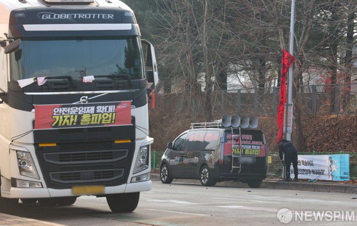 [서울=뉴스핌] 황준선 기자 = 공공운수노조 화물연대가 총파업을 철회한 9일 오후 경기도 의왕시 내륙컨테이너기지(ICD)앞 도로에 주차된 화물차에서 한 화물연대 조합원이 총파업 선전 현수막을 철거하고 있다. 2022.12.09 hwang@newspim.com