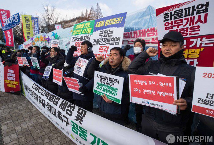 [서울=뉴스핌] 윤창빈 기자 = 민주노총 건설산업연맹, 공공운수노조 조합원들이 22일 오전 서울 여의도 국회 앞에서 열린 건설안전특별법 제정 및 화물 안전운임제 유지-확대 촉구 공동 기자회견에서 구호를 외치고 있다. 2022.12.22 pangbin@newspim.com