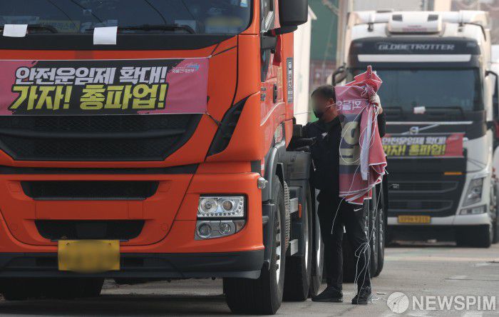 [서울=뉴스핌] 황준선 기자 = 공공운수노조 화물연대가 총파업을 철회한 9일 오후 경기도 의왕시 내륙컨테이너기지(ICD)앞 도로에 주차된 화물차에서 한 화물연대 조합원이 총파업 선전 현수막을 철거하고 있다. 2022.12.09 hwang@newspim.com