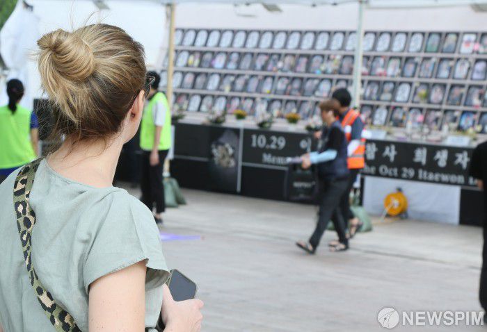 [서울=뉴스핌] 양윤모 기자 = 국가인권위원회가 국회의장에게 `10·29 이태원 참사 피해자 권리보장과 진상규명 및 재발방지를 위한 특별법` 제정안 심의에 속도를 내라는 의견을 표명한 가운데, 10.29 이태원 참사 특별법 신속처리안건 지정촉구 72시간(6/27~6/30) 비상행동선포 기자회견이 27일 오전 서울광장 분향소 앞에서 10.29이태원참사 유가족협의회와 10.29이태원참사 시민대책회의 주최로 개최 되었다. 외국인 관광객이 행사장의 영정 사진을 보며 생각을 하고있다. 2023.06.27 yym58@newspim.com