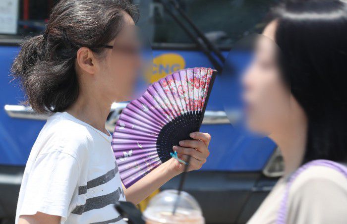 [서울=뉴스핌] 최지환 기자 = 서울 낮 최고기온이 35도까지 올라가며 첫 폭염주의보가 내려진 19일 오후 서울 종로구 광화문네거리에서 한 시민이 부채를 부치며 이동하고 있다. 2024.06.19 choipix16@newspim.com
