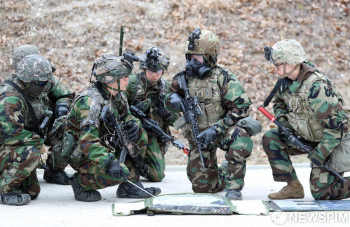 [파주=뉴스핌] 사진공동취재단 = 12일 경기 파주시 무건리 훈련장에서 2025 FS/TIGER 일환으로 실시된 유무인 복합전투체계 활용 '한미연합 WMD(대량살상무기) 제거훈련'에서 마동혁 25사단 해룡여단 중령과 윌리엄 테일러 미2사단/한미연합사단 스트라이커여단 중대장이 작전 토의를 하고 있다. 2025.03.12 photo@newspim.com