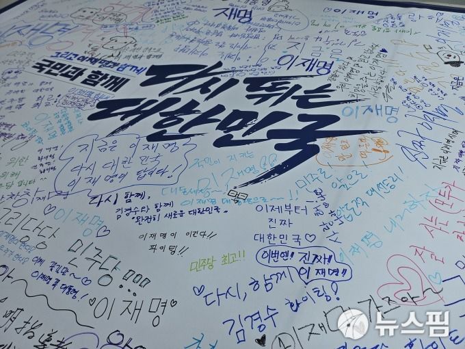 [청주=뉴스핌] 윤채영 기자 = 후보자들 부스 옆에는 '민주당 희망 깃발 꾸미기' 부스도 설치돼 있었다. 여기에는 교실 칠판 크기의 흰 도화지에 사람들이 응원 메시지를 남기거나 낙서할 수 있게 돼 있었다. 2025.04.19 ycy1486@newspim.com