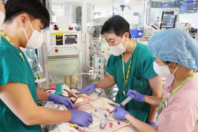 [사진=서울아산병원] 서울아산병원 신생아과 이병섭(왼쪽에서 두번째), 정의석(왼쪽에서 첫번째) 교수 등 의료진이 에크모 도관삽입술을 받은 선천성 횡격막 탈장 환아 상태를 살펴보고 있다.