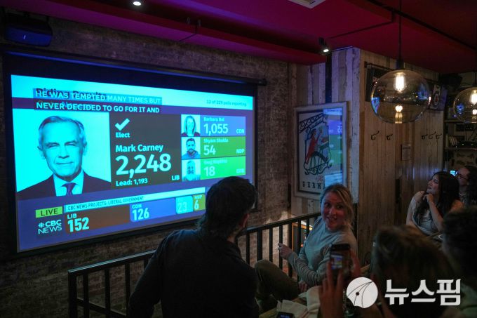 28일(현지시간) 미국 뉴욕 맨해튼의 한 와인 바에서 사람들이 캐나다 총선 개표 결과를 시청하고 있다. [사진=로이터 뉴스핌]