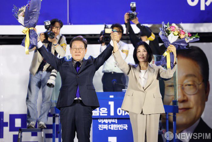 [서울=뉴스핌] 윤창빈 기자 = 이재명 제21대 대통령 당선인이 부인 김혜경 여사 4일 서울 여의도 국회 정문 앞에 마련된 개표방송 야외무대에서 시민들에게 인사를 하고 있다. 2025.06.04 pangbin@newspim.com 2025.06.04 pangbin@newspim.com