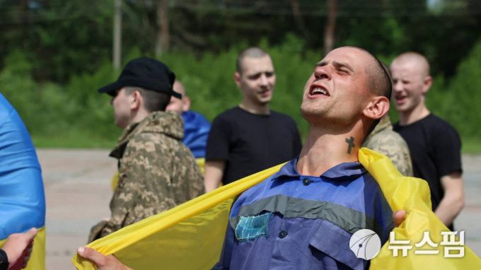[우크라이나 로이터=뉴스핌] 장일현 특파원 = 우크라이나와 러시아가 9일(현지시간) 2차 포로 교환을 시작한 가운데, 고국으로 돌아온 우크라이나 병사가 자유를 만끽하는 표정으로 환호하고 있다. 이날 포로 교환 장소와 시간 등을 공개되지 않았다. 2025.06.09. ihjang67@newspim.com