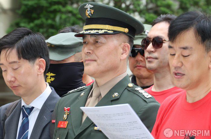 [서울=뉴스핌] 양윤모 기자 = 이재명 대통령이 채상병 특검으로 이명현 전 국방부 검찰단 고등검찰부장을 지명한 가운데, 해병대 '채 상병 순직 사건'과 관련해 항명 및 상관명예훼손 혐의로 기소된 박정훈 전 해병대 수사단장(대령)이 13일 서울 서초구 서울고등법원에서 열린 항소심 첫 공판에 출석하며 김태성 후원회장이 입장문을 경청하고 있다. 2025.06.13 yym58@newspim.com