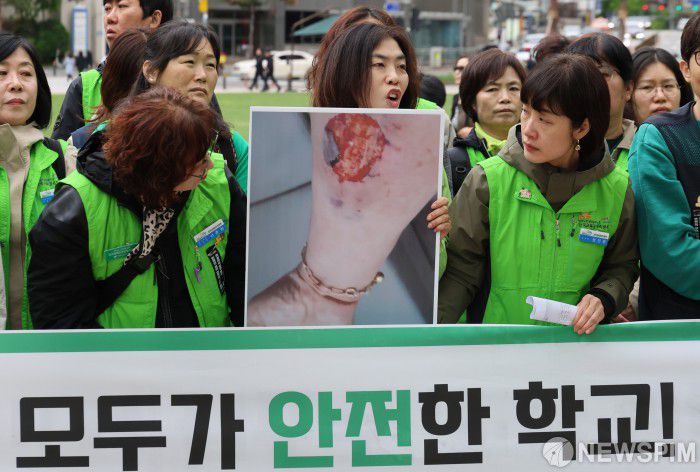 [서울=뉴스핌] 양윤모 기자 = 특수교육지도사가 24일 오전 서울 중구 서울시청 앞에서 민주노총 공공운수노조 전국교육공무직본부주최로 개최된 급식실 노동자 건강권 쟁취 대책 마련을 촉구집회에서 사고당한 동료지도사의 사진을 들고 발언하고 있다.  급식실 환기시설 개선 예산 조속한 집행과 추가 안전대책 마련을 비롯해 학교 현업업무 지정 확대 및 충실한 관리·감독 이행, 다양한 직종의 노동안전 대책 마련 등을 요구했으며 ,이자리에는 급식조리원,도서관 사서,특수교육 지도사,환경실무사,과학실무사등 교육공무직본부 조합원이 참석했다. 2024.04.24 yym58@newspim.com