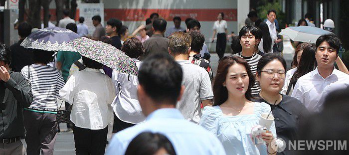 [서울=뉴스핌] 이형석 기자 = 무더위가 이어지며 체감온도가 33도를 넘나드는 1일 오후 서울 여의도 인근에서 시민들이 양산을 쓰고 발걸음을 재촉하고 있다. 2025.07.01 leehs@newspim.com