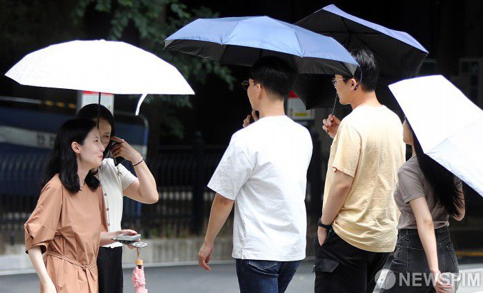 [서울=뉴스핌] 이형석 기자 = 무더위가 이어지며 체감온도가 33도를 넘나드는 1일 오후 서울 여의도 인근에서 시민들이 양산을 쓰고 발걸음을 재촉하고 있다. 2025.07.01 leehs@newspim.com