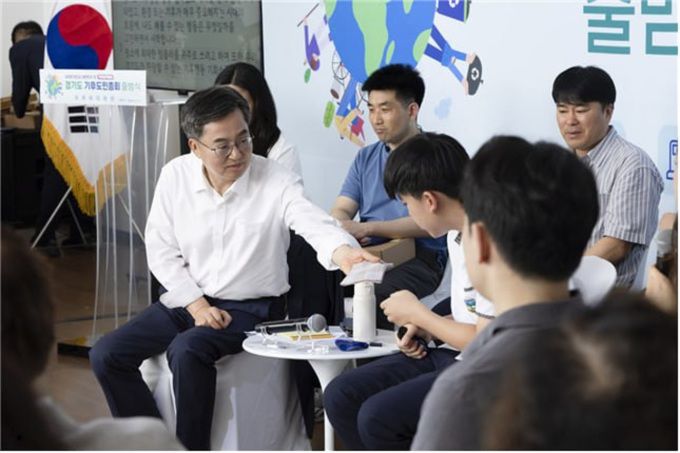 김동연 도지사가 지난달 30일 시흥에코센터에서 진행된 <경기도 기후도민총회 출범식>에서 땀 흘리는 학생 참가자에게 손수건을 건네고 있다. [사진=경기도]