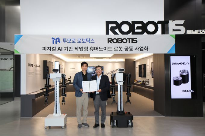 로보티즈 김병수 대표(왼쪽)과 투모로 로보틱스 장병탁 대표가 협약서를 들고 기념촬영을 하고 있다. [사진=로보티즈]