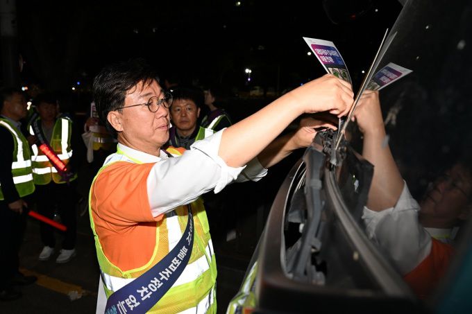 이민근 안산시장이 지난해 10월 상록구와 단원구 대형자동차 불법주청자 현장계도에 나서 직접 차량에 단속 계도물을 부착하고 있다. [사진=안산시]