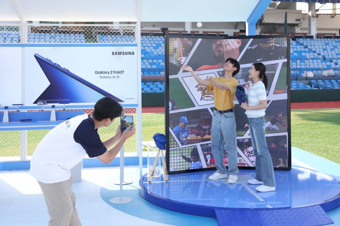 대전 중구 한화 이글스파크 '갤럭시 체험존'에서 방문객들이 '갤럭시 Z 폴드7'과 함께 구단별 하이라이트 영상을 배경으로 인증샷을 촬영하는 모습. [사진=삼성전자]