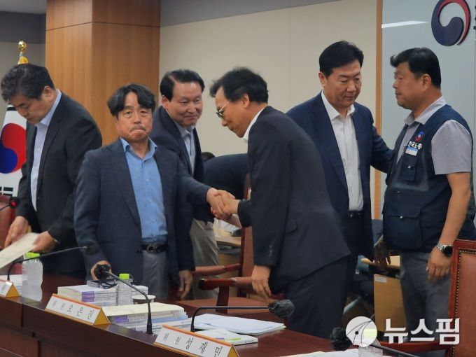 [세종=뉴스핌] 양가희 기자 = 17년 만에 최저임금이 노사 합의로 결정된 가운데, 이인재 최저임금위원장(왼쪽)이 기념사진 촬영 이후 자리를 정리하고 있다. 하헌제 최저임금위원회 상임위원(왼쪽 세번째)은 이명로 중기중앙회 인력정책본부장(왼쪽 네번째)와 악수하고 있다. 류기정 경총 전무(왼쪽 다섯번째)는 류기섭 한국노총 사무총장(왼쪽 여섯번째)의 어깨를 두드리고 있다. 왼쪽 두번째는 공익위원 간사 권순원 숙명여대 교수. 2025.07.11 sheep@newspim.com