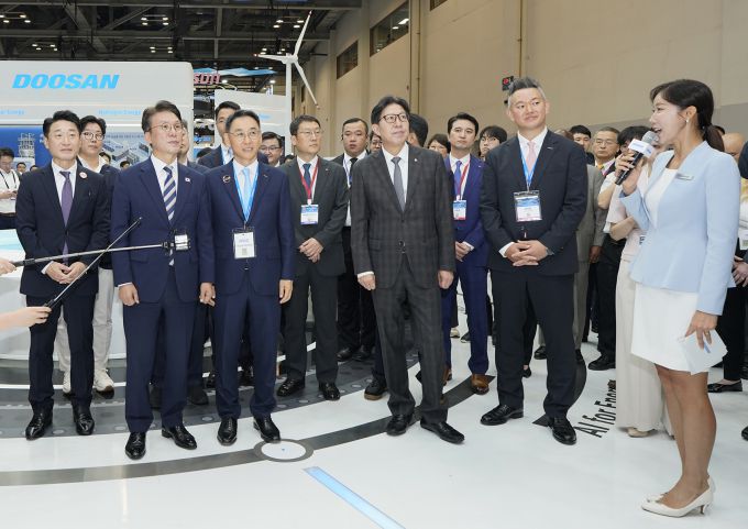 '기후산업국제박람회' 두산 부스에 주요 인사들이 방문해 두산그룹의 에너지 솔루션 기술을 살펴보고 있다. 앞줄 왼쪽부터 이호현 산업통상자원부 2차관, 김민석 국무총리, 정연인 두산에너빌리티 부회장, 박형준 부산광역시장 [사진=두산]