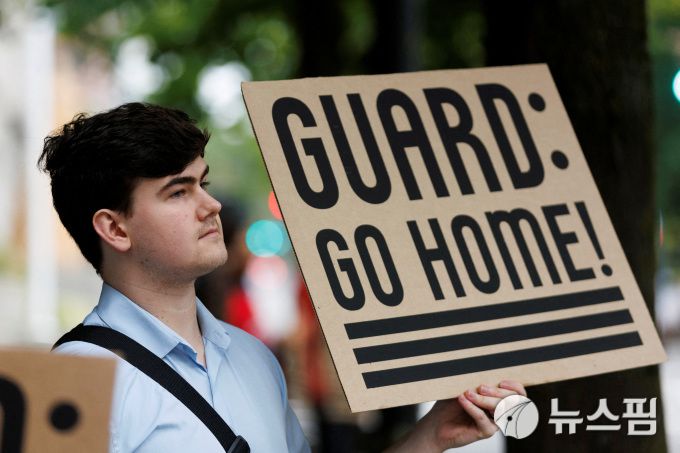 2025년 10월 3일, 미국 오리건주 포틀랜드의 마크 O. 해트필드 연방법원 앞 집회에서 한 시위자가 도널드 트럼프 대통령의 포틀랜드 내 주 방위군 배치 계획에 대한 카린 이머굿 연방지방법원 판사의 판결을 앞두고 팻말을 들고 있다.﻿[사진=로이터 뉴스핌]