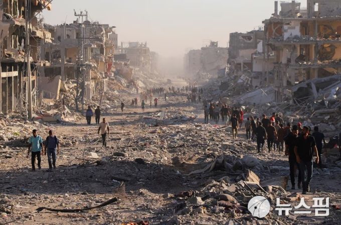 [가자시티 로이터=뉴스핌] 장일현 특파원 = 이스라엘과 하마스의 휴전 협정이 공식 발표된 10일(현지 시간) 가자지구 내 최대 도시인 가자시티 시내를 주민들이 걷고 있다. 가자시티는 최근 이스라엘군의 재점령 작전으로 거의 폐허 수준으로 변했다. 2025.10.10. ihjang67@newspim.com