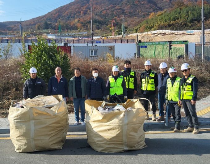 양산환경연합의 양산시 동면 사송 일대에 건립 중인 LH아파트 공사현장 주변의 쓰레기 무단투기 환경정화활동 후 가진 기념사진 모습.[사진=양산환경연합] 2025.11.27
