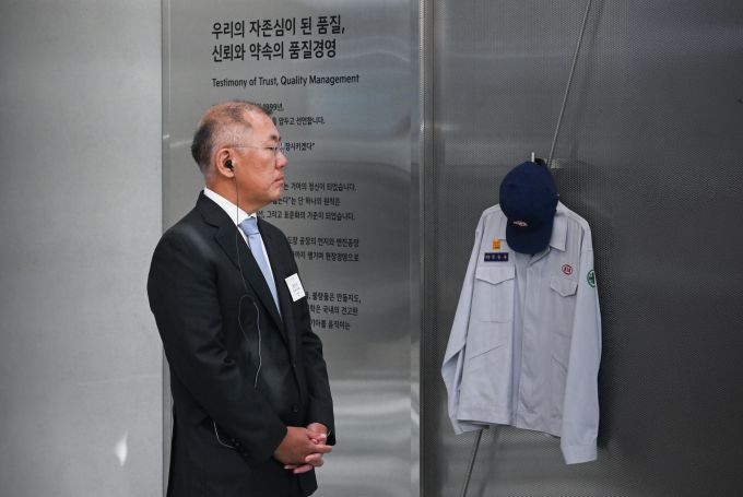 기아 80주년 기념 전시 '움직임의 유산'에서 정몽구 명예회장의 실제 작업복을 둘러보는 정의선 현대자동차그룹 회장 [사진=기아]