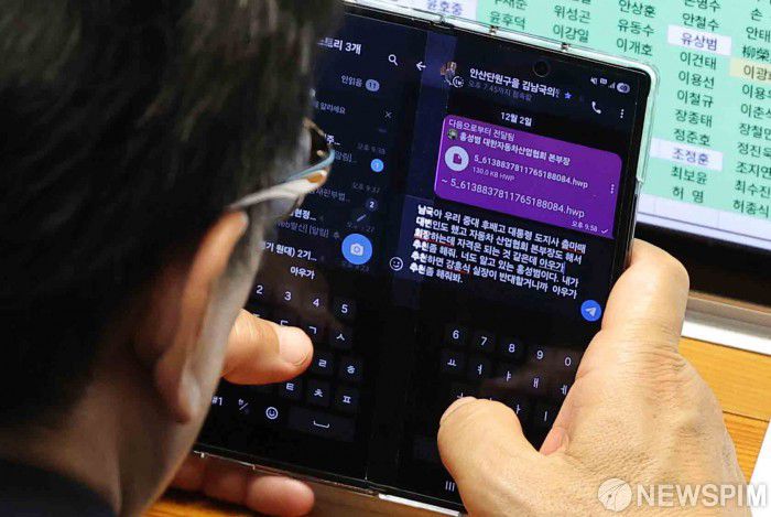 [서울=뉴스핌] 윤창빈 기자 = 문진석 더불어민주당 원내운영수석부대표가 2일 서울 여의도 국회에서 열린 본회의에서 김남국 대통령비서실 국민디지털소통비서관에게 문자를 보내고 있다. 문자에는 홍성범 한국자동차산업협회 상무를 회장으로 추천해 달라는 내용이 담겼다. 문 수석은 '내가 추천하면 강훈식 실장이 반대할거니까 아우가 추천좀 해줘봐' 라고 전달했다. 2025.12.02 pangbin@newspim.com