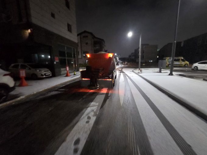 4일 저녁 강설이 내린 가운데 배곧동의 한 도로에서 제설차가 도로에 쌓인 눈을 치우고있다. [사진=시흥시]
