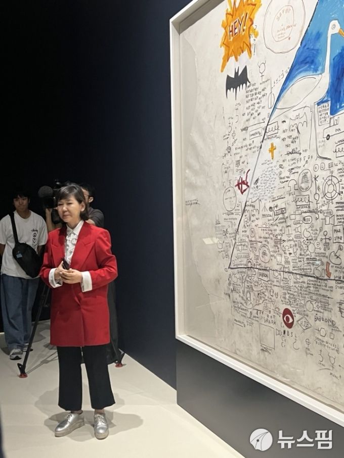 [서울=뉴스핌] '장 미셸 바스키아: 과거와 미래를 잇는 상징적 기호들'전을 총괄 기획한 이지윤 숨 프로젝트 큐레이터가 출품작을 설명하고 있다. C 장 미셸 바스키아 [사진=이영란 미술전문기자] 2025.12.26 art29@newspim.com