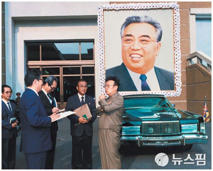 [서울=뉴스핌] 이영종 통일전문기자 = 김정일(오른쪽) 북한 국방위원장이 1994년 7월 사망한 아버지 김일성의 장례 운구차를 어떻게 꾸밀지를 두고 간부들과 논의하고 있다. 뒤편으로 운구에 쓰일 미제 링컨컨티넨 리무진과 김일성 대형 초상화가 보인다. [사진=북한 화보] 2026.01.08 yjlee@newspim.com