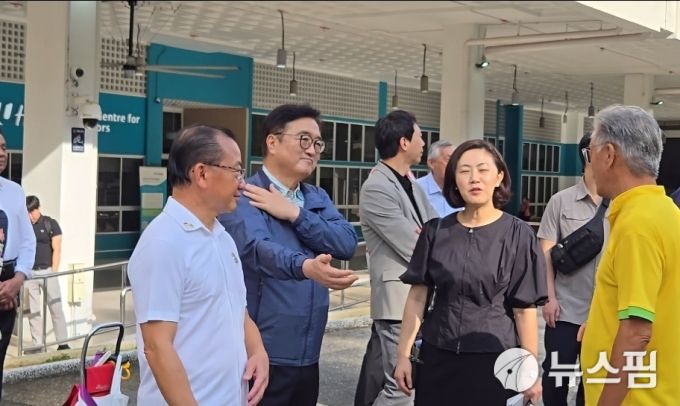 [싱가포르=뉴스핌] 신정인 기자 = 우원식 국회의장이 20일(현지시각) 싱가포르 커뮤니티 허브 야외 강당에서 어르신들의 운동 시간에 맞춰 시아 의장과 함께 체조를 따라하고 있다. 2026.01.20 allpass@newspim.com