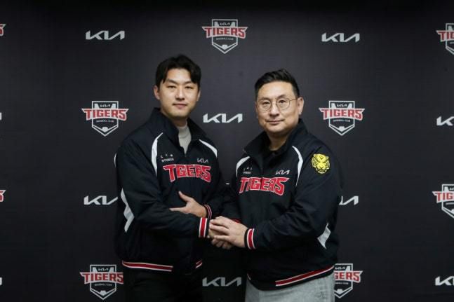 홍건희(왼쪽)와 심재학 단장이 FA 계약한 뒤 기념 사진 촬영을 하고 있다. [사진 = KIA]