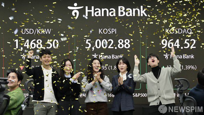 [서울=뉴스핌] 양윤모 기자 = 22일 오전 코스피가  5000 을 돌파하자 서울 중구 하나은행본점 딜링룸에서 직원들이 환호하고 있다. 2026.01.22 yym58@newspim.com