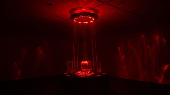 전시 작품 '완벽을 완성하는 이름 '파괴''와 미디어 아트 '점화'. 공간은 화려한 레이저 효과와 함께 끓어오르는 에너지로 가득 차 있다. [사진=데브시스터즈]