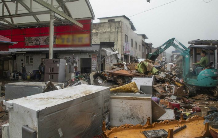 구례 읍내에서 굴착기가 거리에 쏟아져나온 침수 피해 가구와 가전 등을 치우고 있지만 역부족이다.(사진=구례군 제공)