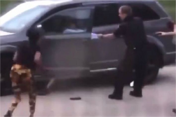 경찰이 총을 쏜 후 한 여성이 다가와 팔짝팔짝 뛰고 있는 모습(사진=연합뉴스)